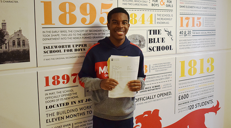 Tinashe Chituku stands with his GCSE results in the main school corridor.