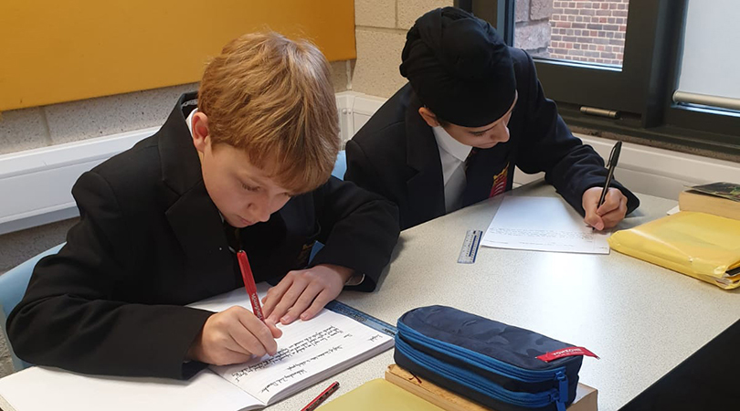 Two students writing letters.