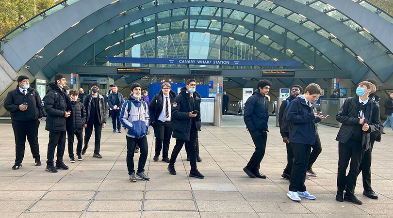 Geography sudents investigate the Canary Wharf area, with some doing research on their mobile phones.