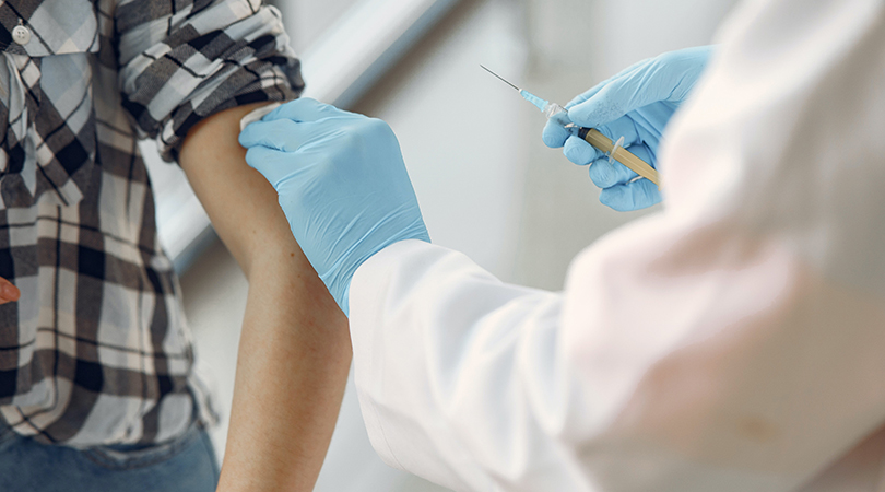 Someone holds a needle as part of the vaccinations programme.