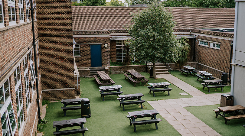 One of the school's quadrangles, with a series of benches on astroturf. 