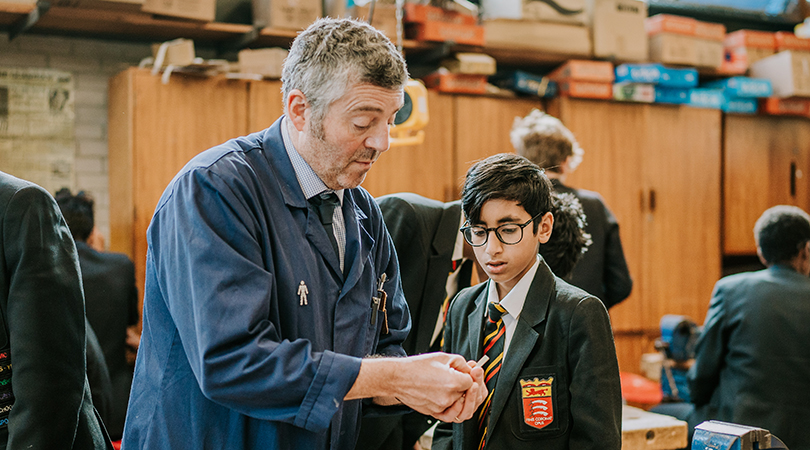 A teacher with greying hair and a student with glasses.